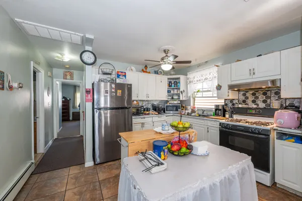 a kitchen that has a lot of cabinets and refrigerator in it
