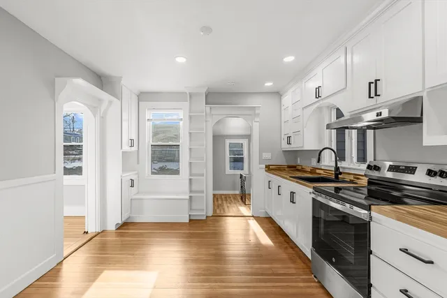 a large kitchen with stainless steel appliances granite countertop a stove and a refrigerator