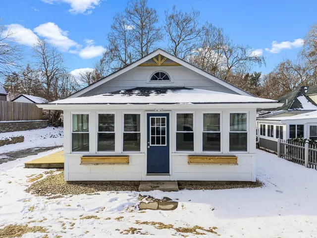 a front view of a house with a yard covered in snow