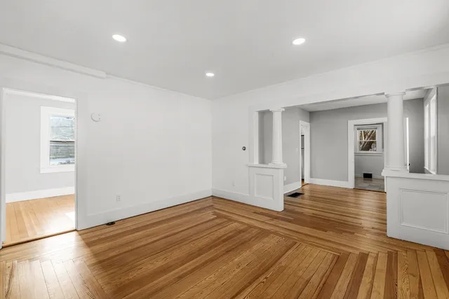 a view of empty room with wooden floor and fireplace