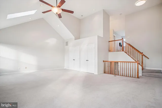 an empty room with a ceiling fan and a window