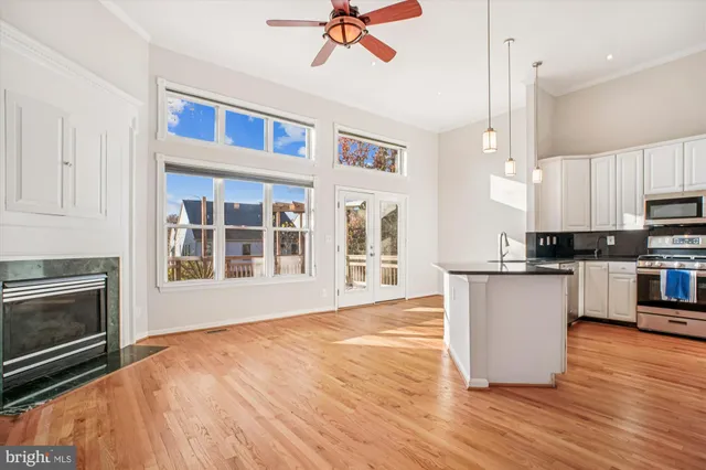 a kitchen with stainless steel appliances granite countertop a stove a sink and white cabinets