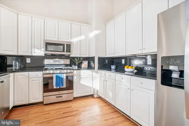 a view of a kitchen counter space a stove and a window