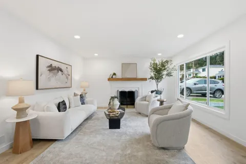 a view of a dining room and livingroom with furniture wooden floor a chandelier