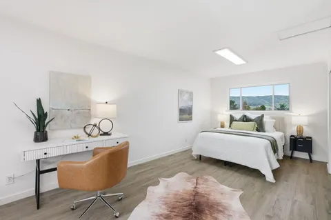 a bedroom with a bed and a large window