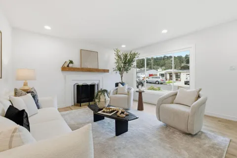a living room with furniture and a dining table with wooden floor
