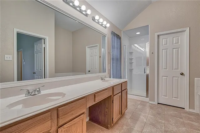 a bathroom with a sink double vanity granite tub and a mirror