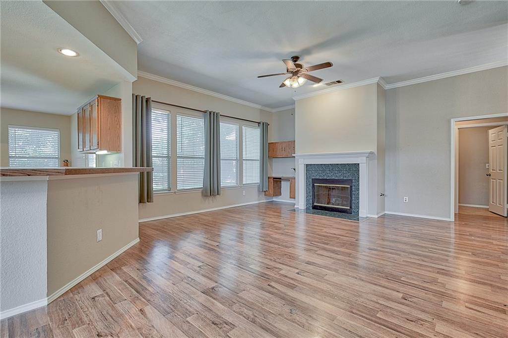 404 Faircloud Lane McKinney, TX 75072 - Photo 4 of 26 an empty room with wooden floor fireplace and windows