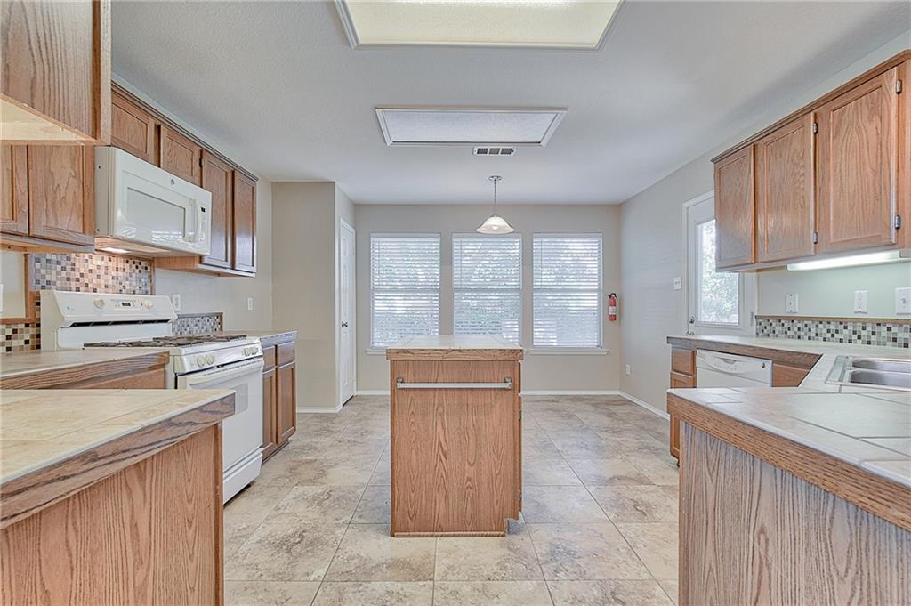 404 Faircloud Lane McKinney, TX 75072 - Photo 9 of 26 a kitchen with a cabinets and white appliances