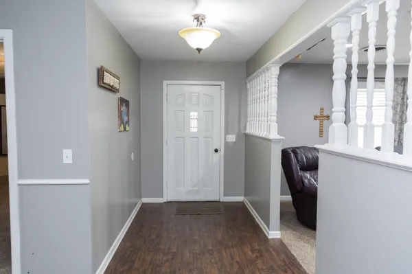 a view of a hallway with wooden floor and a window