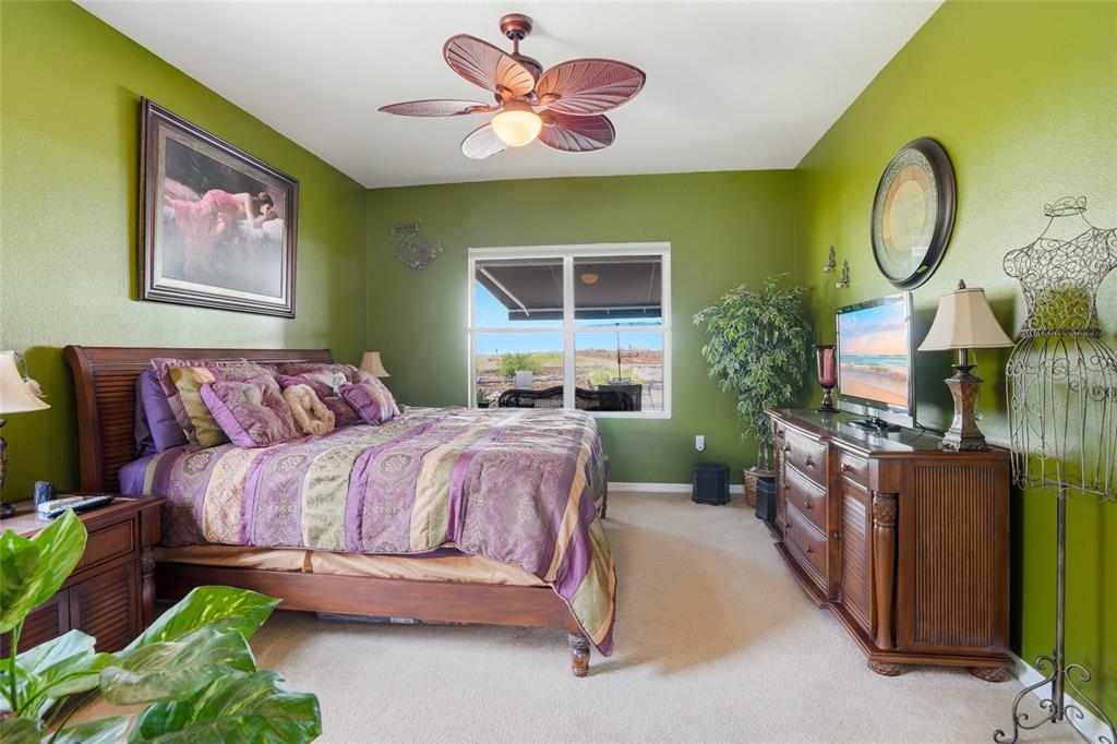 4154 Braemere Drive Spring Hill, FL 34609 - Photo 12 of 95 a spacious bedroom with a bed a dresser and paintings on the wall