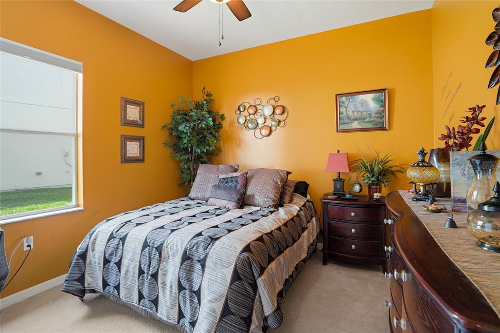 4154 Braemere Drive Spring Hill, FL 34609 - Photo 26 of 95 a bedroom with a bed and a chandelier