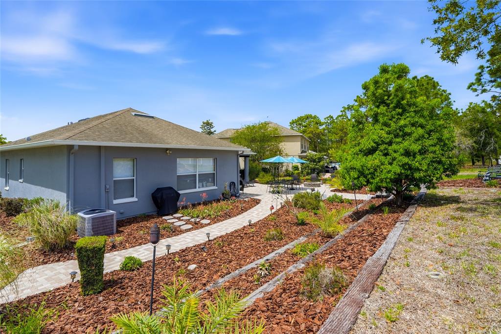4154 Braemere Drive Spring Hill, FL 34609 - Photo 35 of 95 a view of a house with backyard sitting area and garden