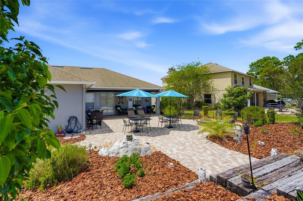 4154 Braemere Drive Spring Hill, FL 34609 - Photo 36 of 95 a view of a patio with table and chairs under an umbrella