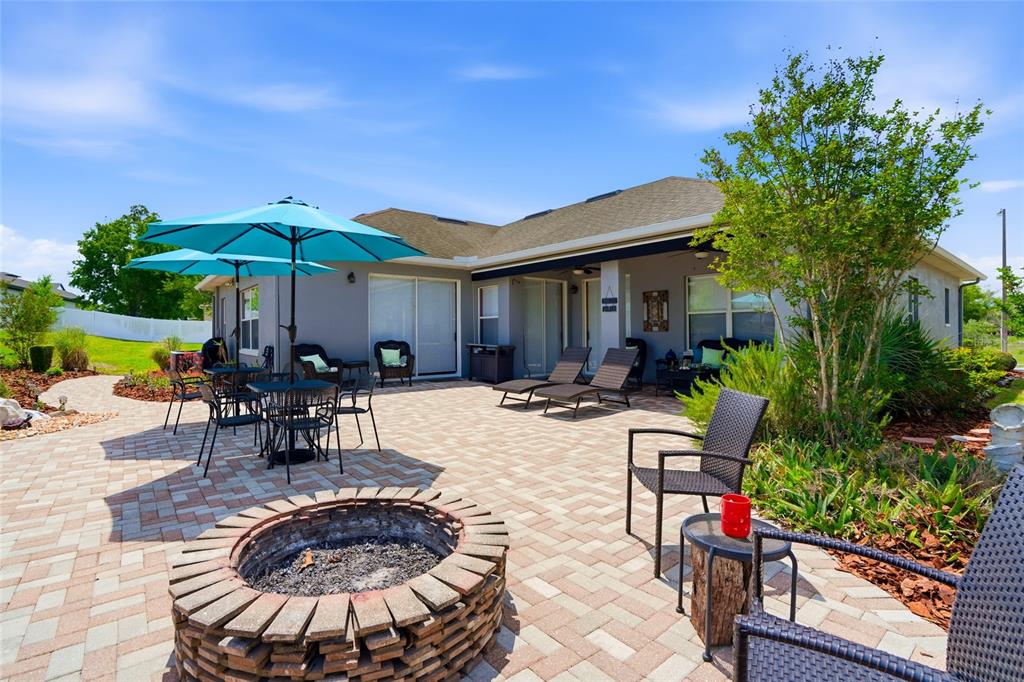 4154 Braemere Drive Spring Hill, FL 34609 - Photo 43 of 95 a view of a patio with couches table and chairs under an umbrella with potted plants