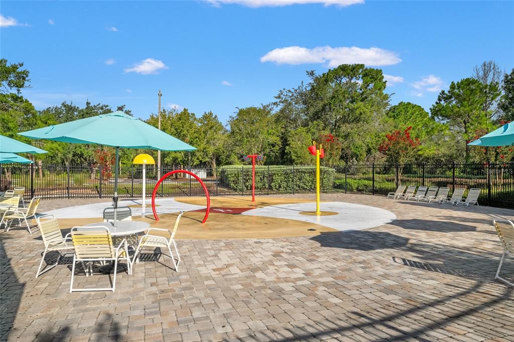 4154 Braemere Drive Spring Hill, FL 34609 - Photo 86 of 95 a view of a swimming pool with a table and chairs under an umbrella