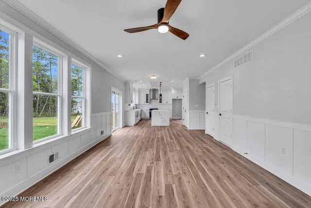 a view of empty room with wooden floor and windows