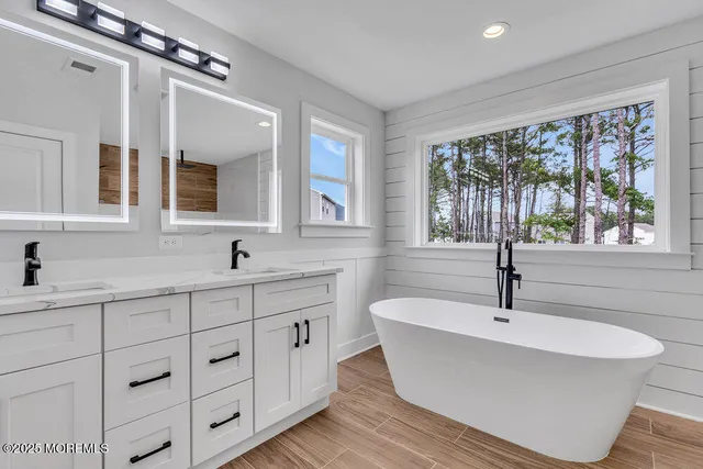 a white bath tub sitting next to a bathroom sink