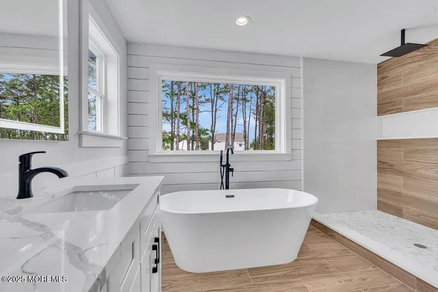 a white bath tub sitting in a bathroom next to a sink