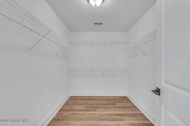 a view of a small space with wooden floor and entryway