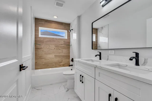 a bathroom with a granite countertop sink a toilet and bathtub