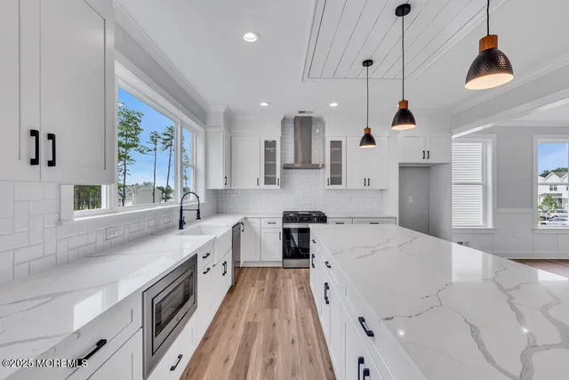 a large kitchen with stainless steel appliances granite countertop a lot of counter space and a sink