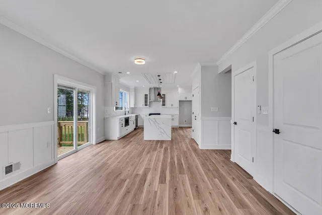 a large white kitchen with wooden floors and white walls