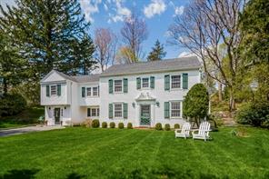 Gracious front yard enclosed with charming white picket fence