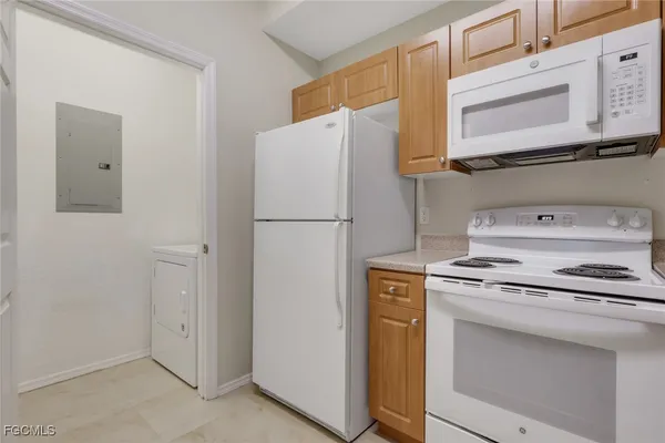 a white refrigerator freezer and a stove sitting inside of a kitchen
