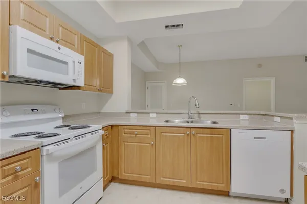 a kitchen with granite countertop a sink stove and cabinets