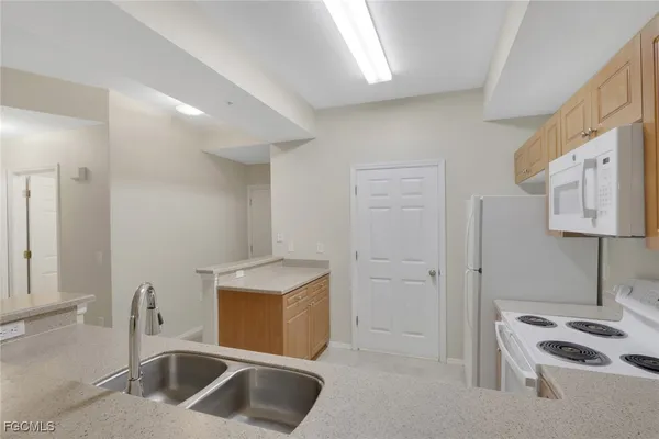 a kitchen with stainless steel appliances kitchen island a sink stove and refrigerator