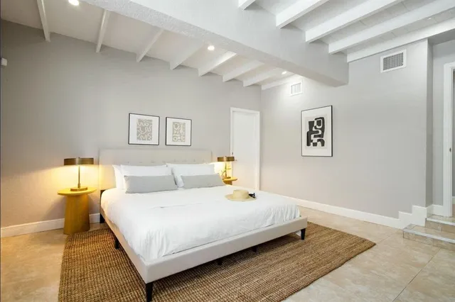 a kitchen with granite countertop a sink stainless steel appliances white cabinets and a window