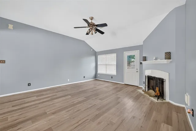 an empty room with windows and fireplace