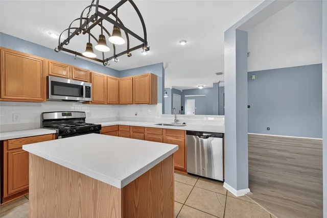 a kitchen with stainless steel appliances a stove sink microwave refrigerator and cabinets