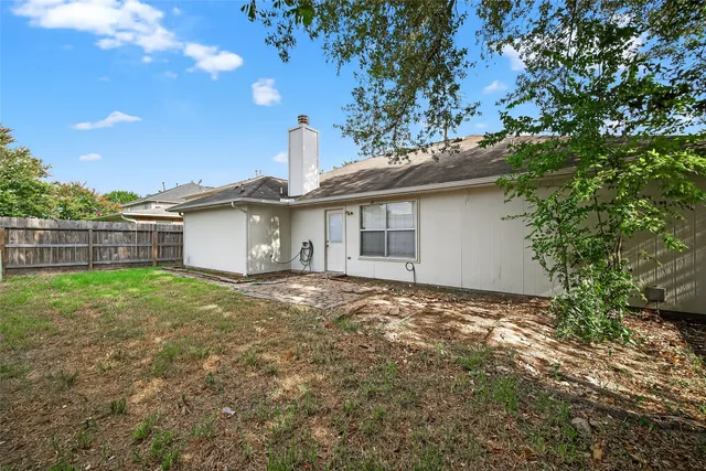 a view of a house with a backyard and a tree