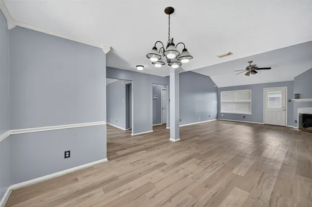 a view of a room with wooden floor and chandelier