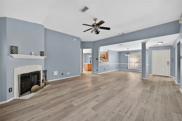 a view of empty room with wooden floor and fireplace