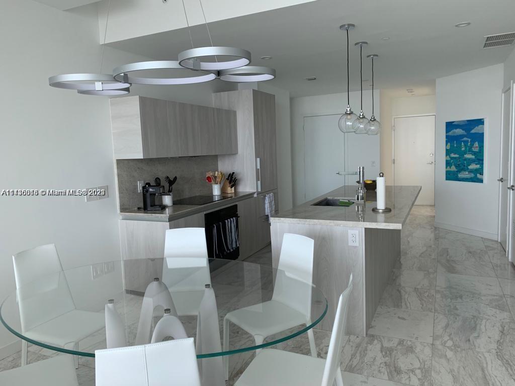Paraiso Bay Miami, FL 33137 - Photo 6 of 9 a dining room with furniture a chandelier and kitchen view