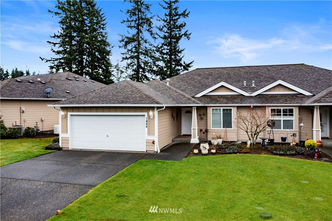 1488 Mountain View Drive, Unit 4 Enumclaw, WA 98022 - Photo 1 of 20 a view of a white house with a yard and table and chairs under an umbrella