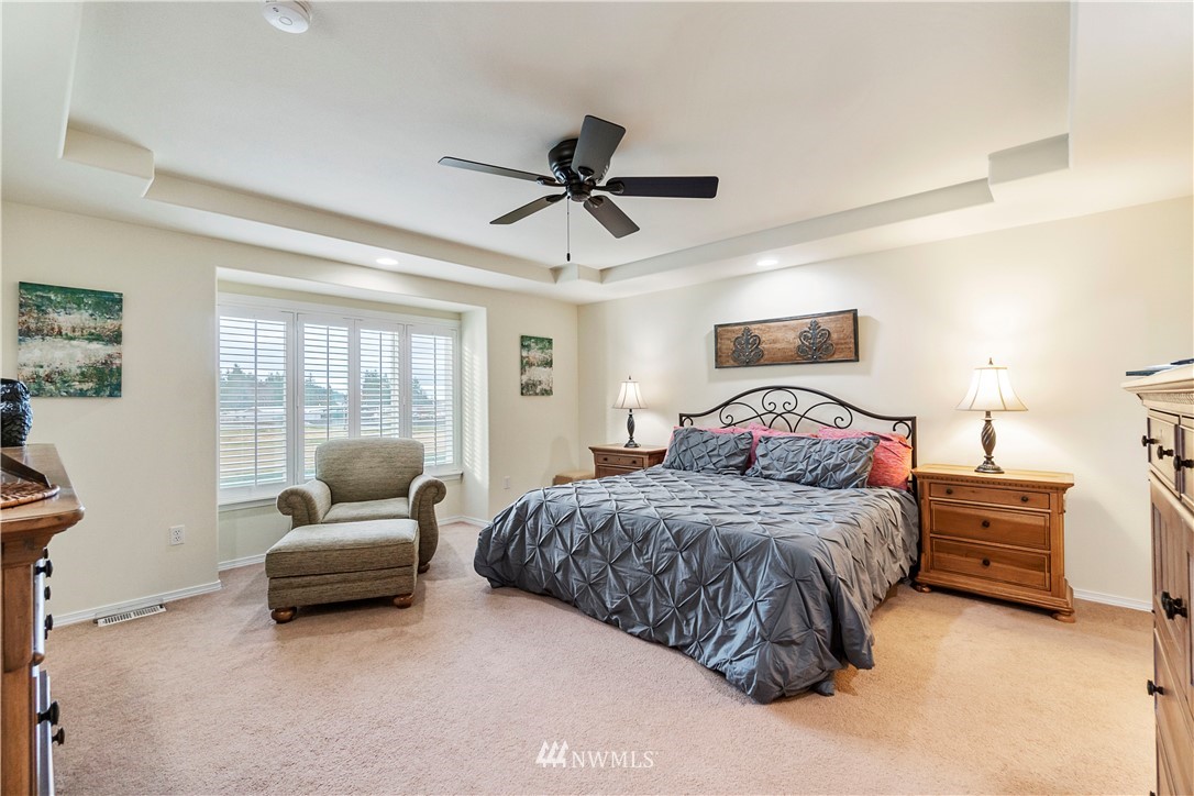 1488 Mountain View Drive, Unit 4 Enumclaw, WA 98022 - Photo 11 of 20 a spacious bedroom with a bed a couch and a chandelier