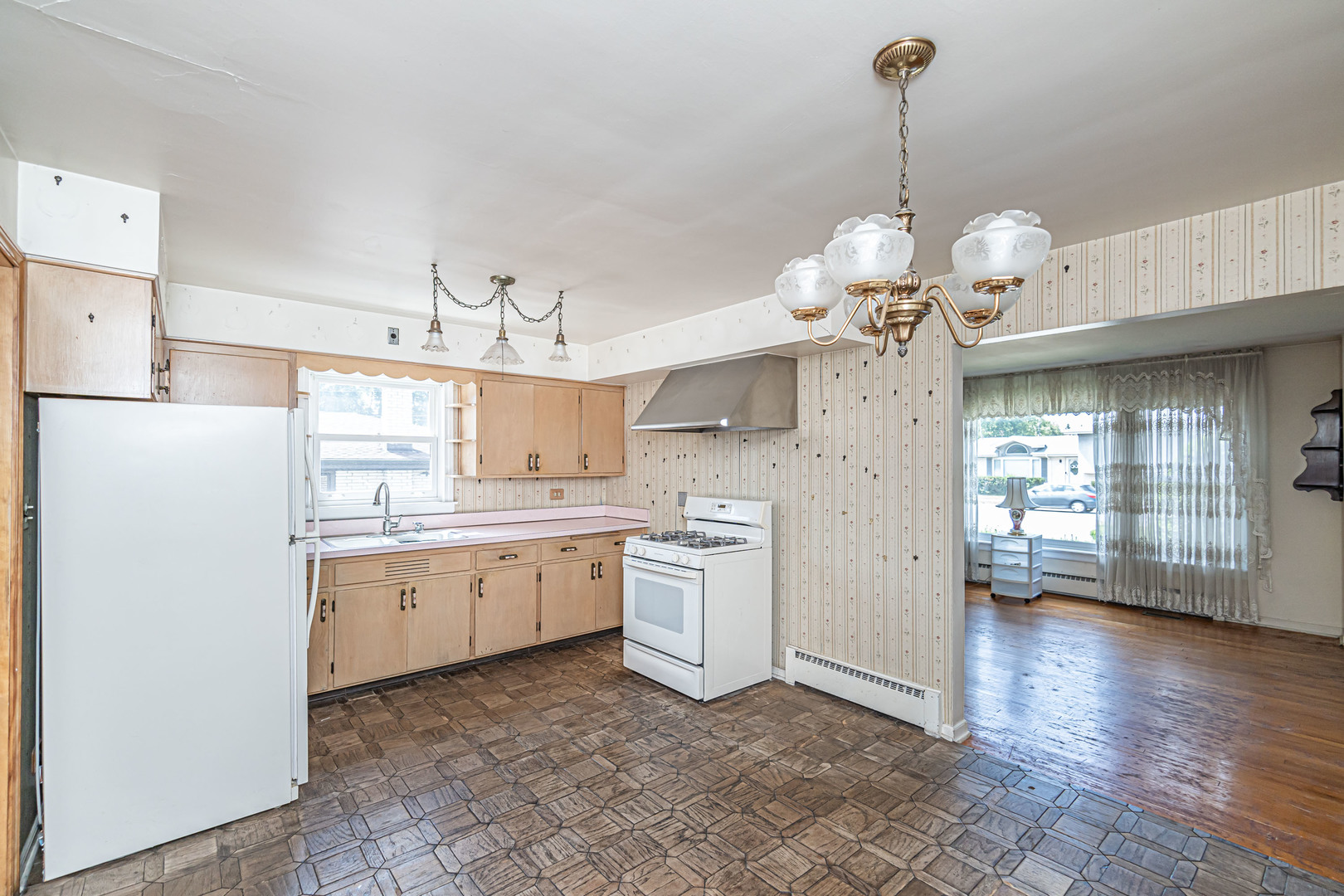 1001 Oakton Street Park Ridge, IL 60068 - Photo 6 of 33 a kitchen with a refrigerator a sink dishwasher a stove and a dining table with wooden floor