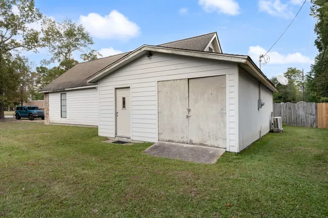 a view of backyard of house with wooden fence