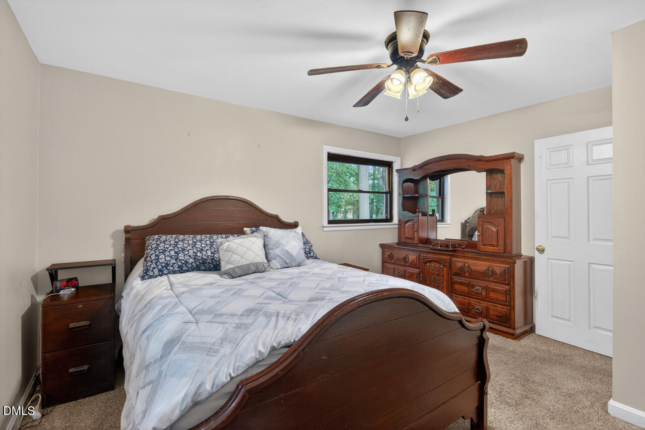 1420 Goodwin Road Durham, NC 27712 - Photo 27 of 54 a bedroom with a large bed and a chandelier