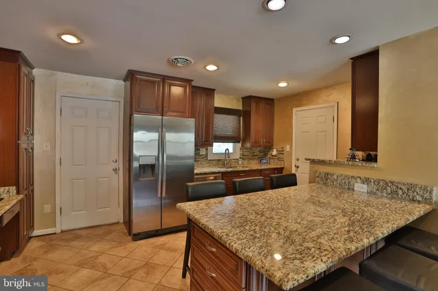 a kitchen with stainless steel appliances granite countertop wooden cabinets and granite counter tops