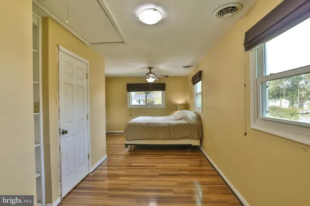 a spacious bedroom with a bed and wooden floor