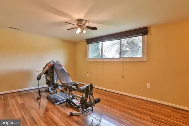 a view of workspace with wooden floor fan and window