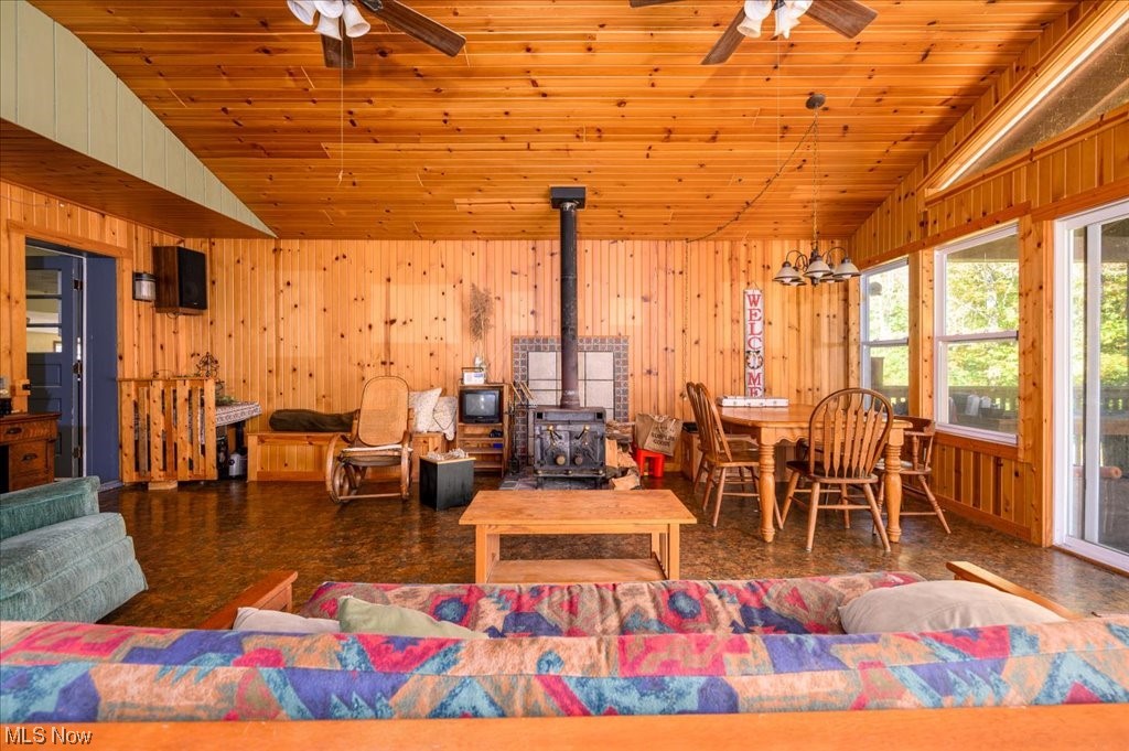 2641 Tower Road Jefferson, OH 44047 - Photo 15 of 35 Living room with vaulted ceiling, a wood stove, and ceiling fan