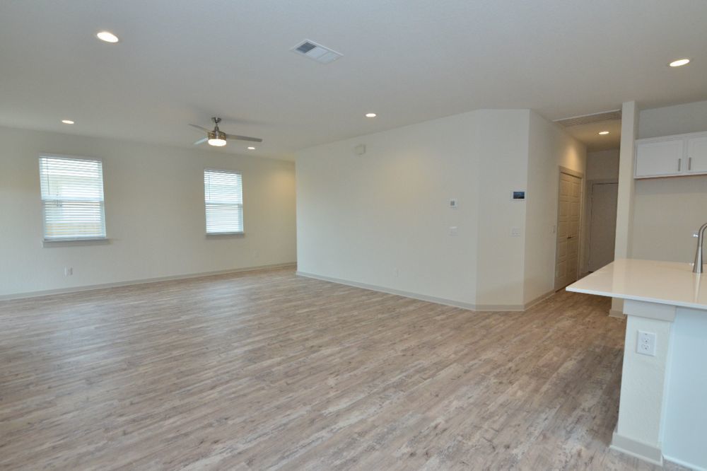 428 Agave Azul Way Leander, TX 78641 - Photo 14 of 24 Durable plank flooring and recessed lighting define this versatile open living space.