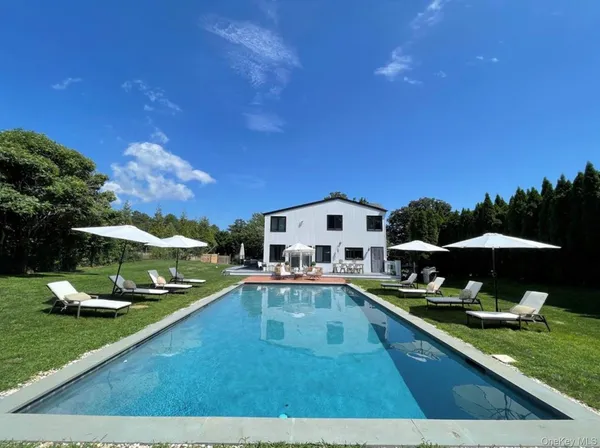 a view of a house with swimming pool and sitting area