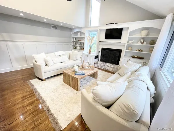 a living room with furniture a flat screen tv and a fireplace